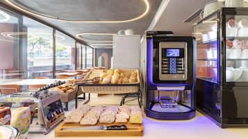Um buffet de café da manhã com pães, doces e uma máquina de café.