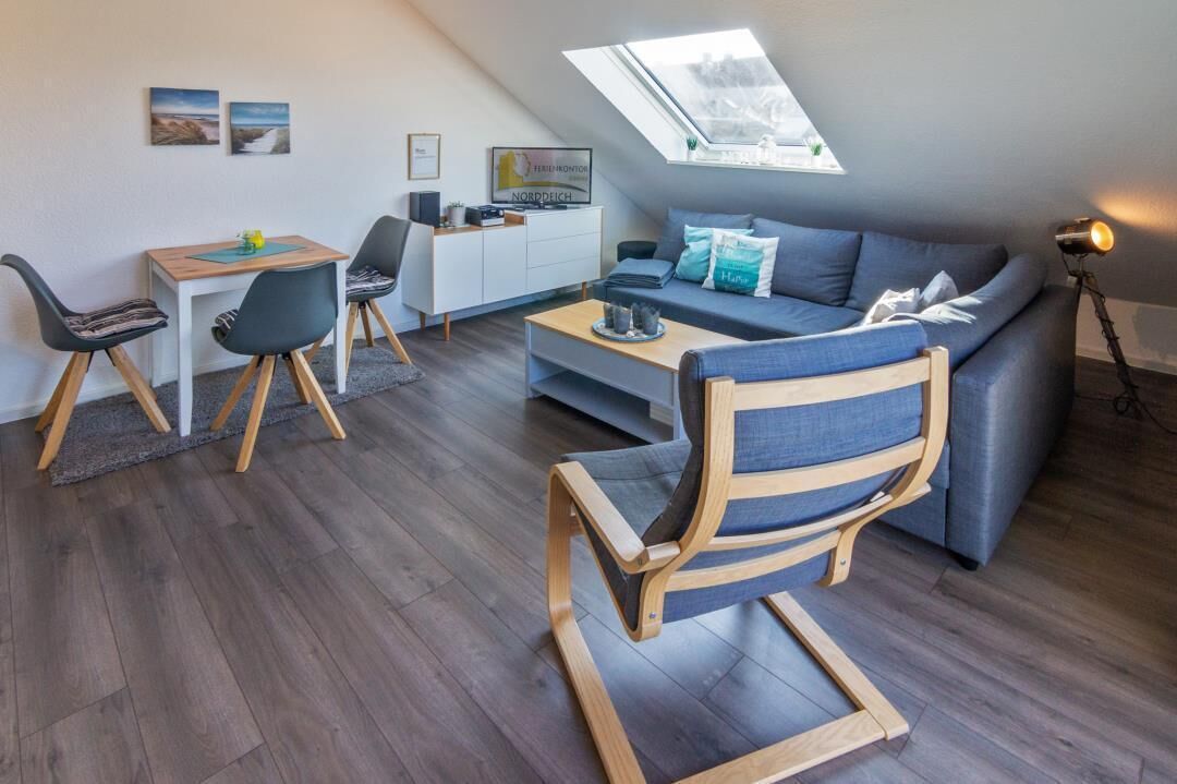Ein modernes Loft-Apartment mit Essbereich, einer Couch und einem Schreibtisch.