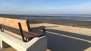 Eine Bank mit Blick auf einen Strand und einen klaren Himmel.