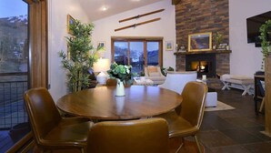 Un coin repas avec une table ronde, des chaises et une cheminée.