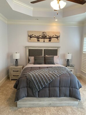 A bedroom with a bed, two bedside tables, a ceiling fan, and a wall-mounted airplane painting. - PROMO 10% WEEKLY DISCOUNT!
Beautiful Home in Champions Retreat (Evans)