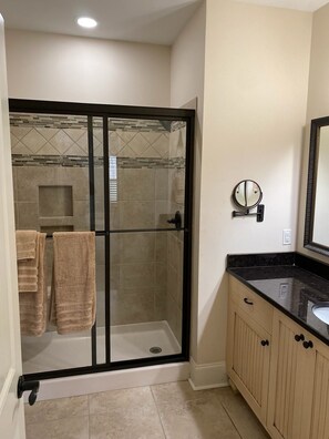 A modern bathroom with a glass-enclosed shower, a sink with a black countertop, and a mirror with a round frame. - PROMO 10% WEEKLY DISCOUNT!
Beautiful Home in Champions Retreat (Evans)