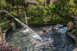 Un área de aguas termales con gente relajándose y bañándose.