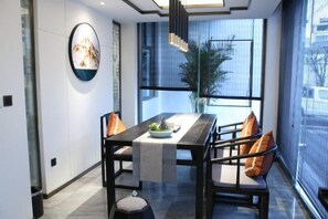 A modern dining area with a long table, chairs, and a decorative centerpiece.