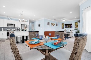 A modern kitchen with white cabinets, a stainless steel refrigerator, and a built-in oven.