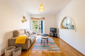 Relax in this inviting living space with a comfortable sofa, TV, and large mirror.