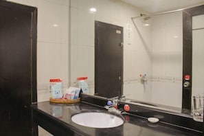 A bathroom with a black sink, a mirror, and a glass shower enclosure. - Xinchangjiang Hotel (Changsha)