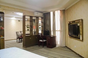 A hotel room with a bed, a desk, a chair, a bookshelf, an air conditioning unit, and a television. - Xinchangjiang Hotel (Changsha)