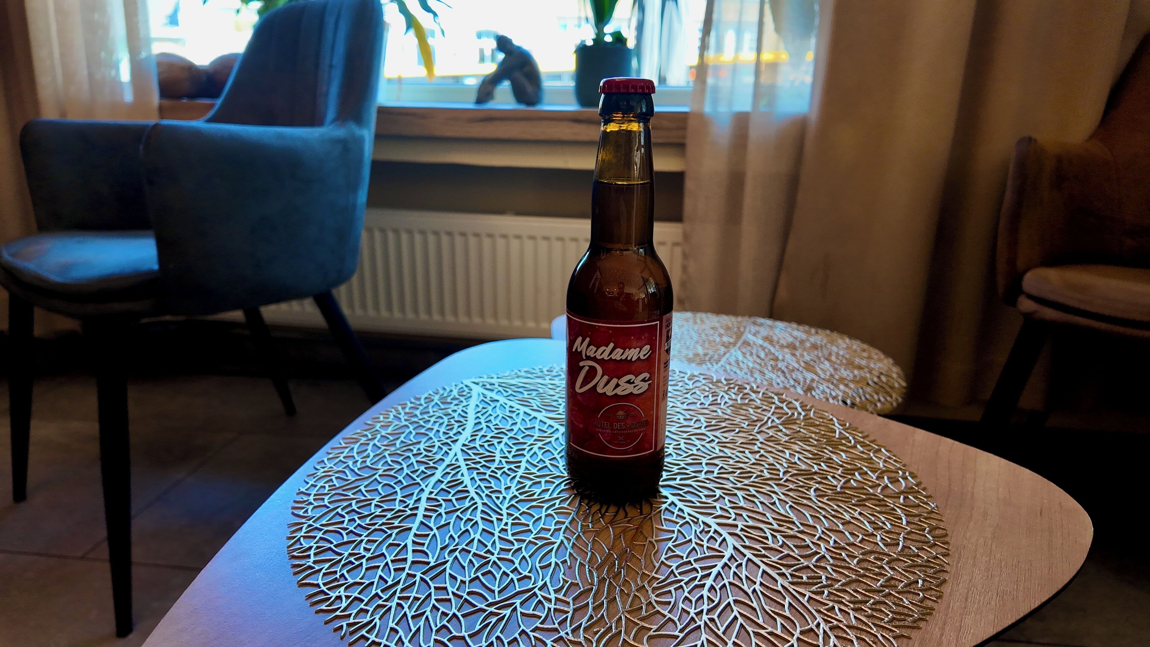 A bottle of Madame Duss on a table with a geometric table runner.