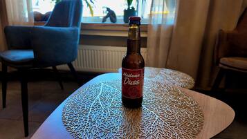 Una botella de Madame Duss sobre una mesa con un camino de mesa geométrico.