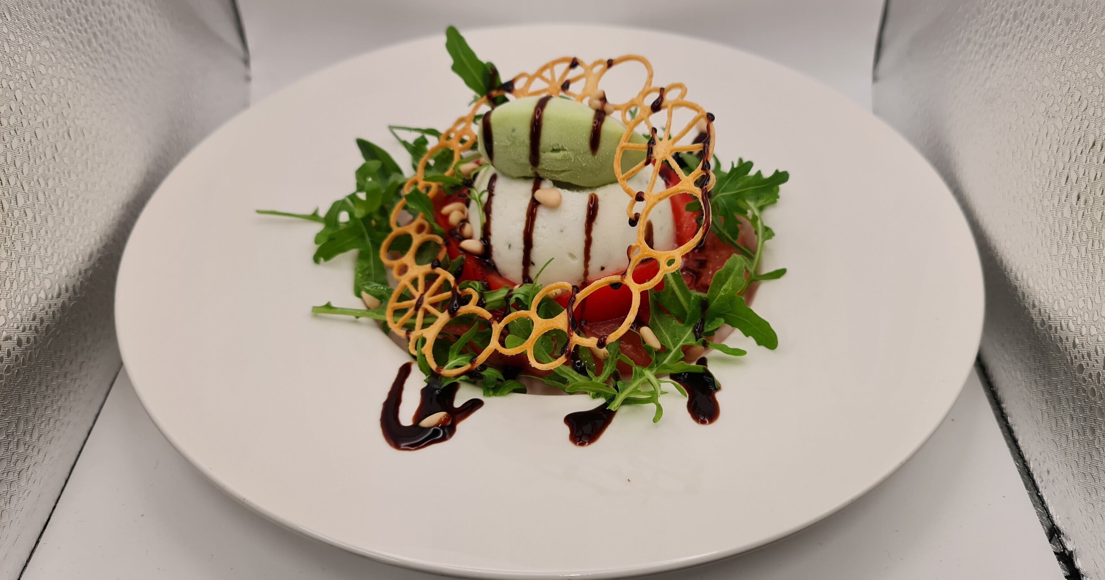 A white plate with a dessert on a textured white tablecloth.