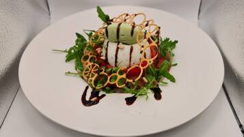A white plate with a dessert on a textured white tablecloth.