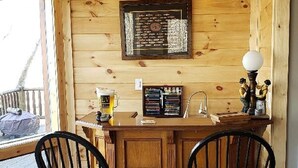 A wooden interior with two black chairs, a wooden bar counter, and a framed certificate on the wall.