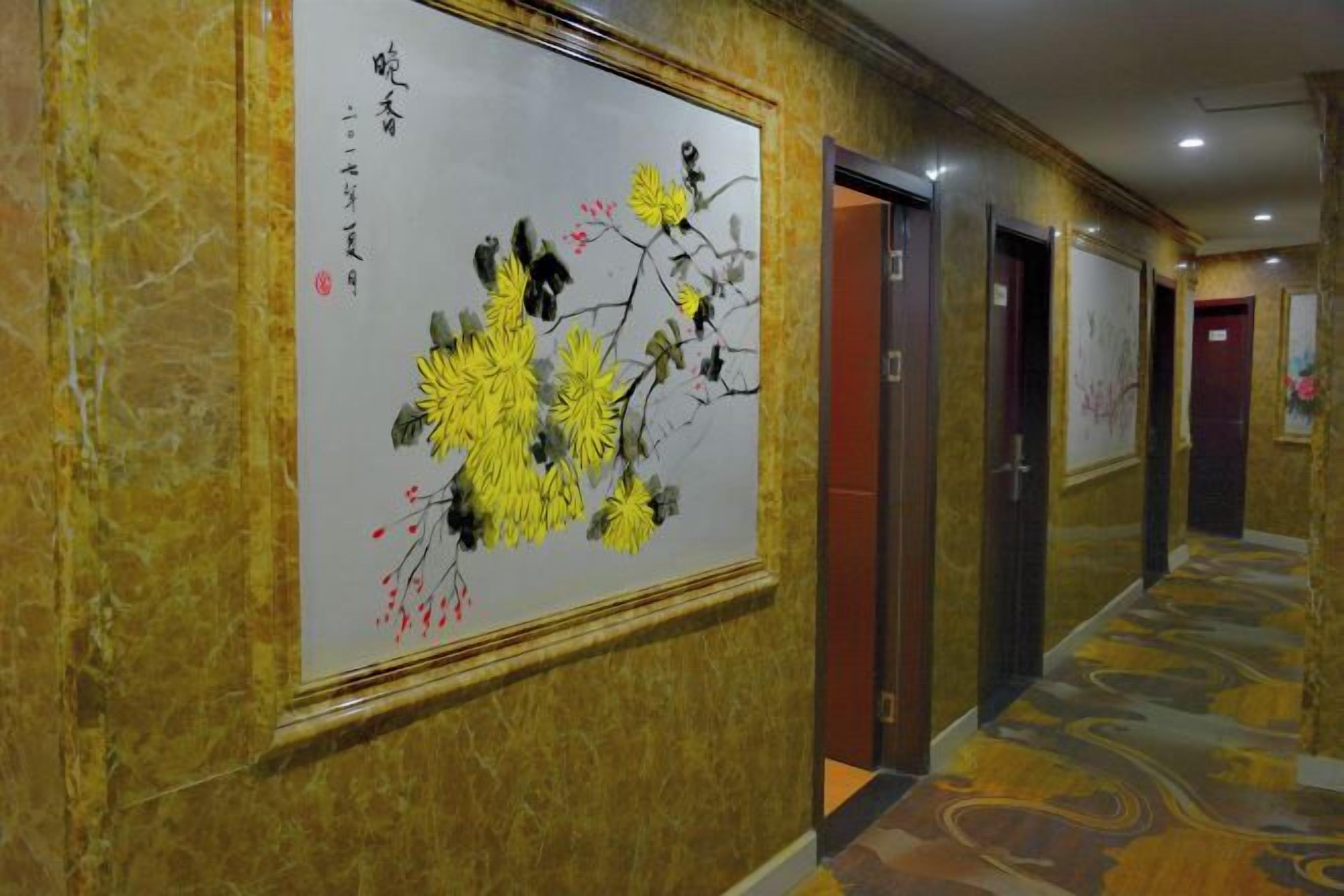 Un couloir orné d’un tableau classique au mur, avec des portes et un tapis à motifs.