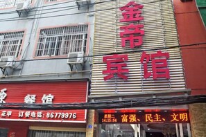 Ein Gebäude mit mehreren Schildern, darunter eines mit der Aufschrift '金宾宾馆' und ein weiteres mit einer Telefonnummer.