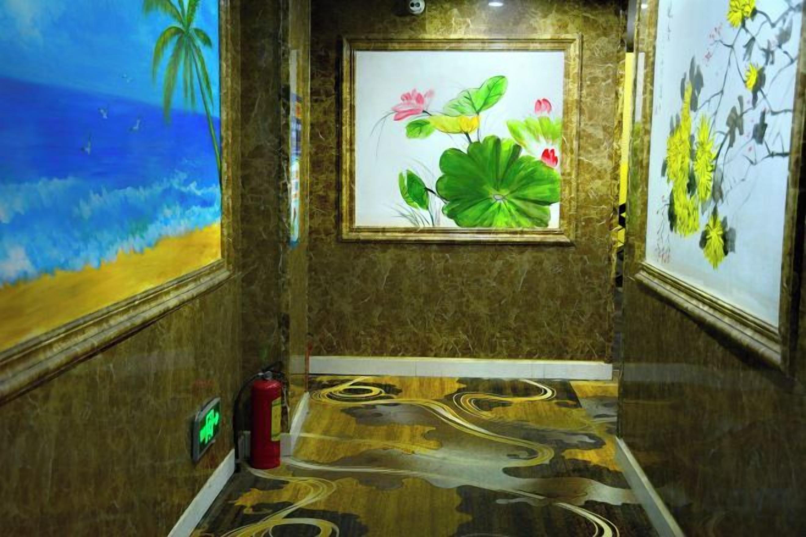 A hallway with a painting of a beach scene, a framed artwork of flowers, and a patterned floor.