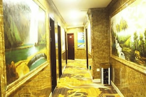 A hallway with marble walls and floor, featuring paintings and doors leading to rooms. - Nanchang Jindi Hotel (Bayiguan Subway Station Branch) (Nanchang)