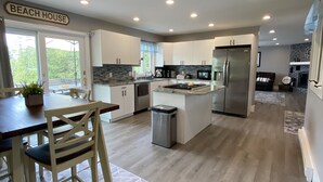 A modern kitchen with white cabinets, a stainless steel refrigerator, and a built-in microwave.