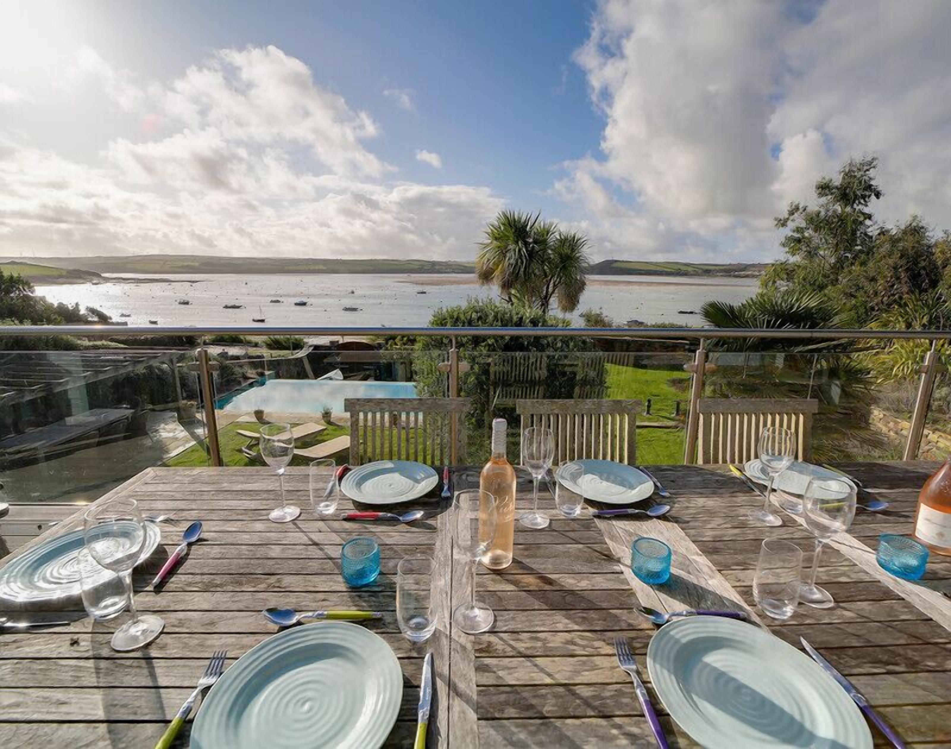 Un área de comedor al aire libre con vistas al mar y barcos.