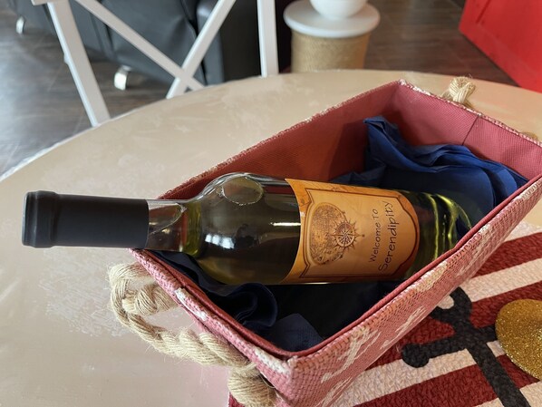 A wine bottle in a woven basket on a table. - Couple's Retreat, Beautiful Boathouse on the Water. (Whitbourne)