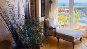 A room with a wooden floor, a bed, a chair, and a large window with a view of the outdoors. - Luxurious Mas with Bassin Balnéo Sea View in Collioure 12 pers (Collioure)