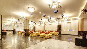 A spacious banquet hall with rows of tables, chandeliers, and a polished floor. - Xenious Grand Manor, Golf Course Extension Road, Gurugram (Gurugram)