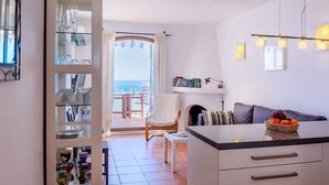 Una cocina moderna con comedor, sofá y vista al mar.
