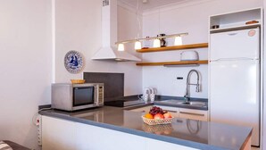 Una cocina moderna con una isla central, microondas integrado y electrodomésticos de acero inoxidable.