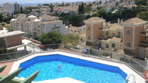 Une piscine entourée d’immeubles d’habitation, avec vue sur la mer.
