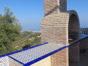A brick chimney with a tiled roof, overlooking a hilly landscape. - SHR018 Villa El Castillo (Torrox)