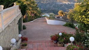 A paved pathway leading to a scenic overlook with mountains in the background.