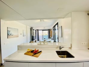 Een moderne keuken met een centraal eiland, een spoelbak en uitzicht op de eetruimte.