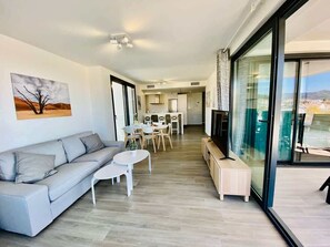 Un salon moderne avec un canapé, une table basse et un coin repas.