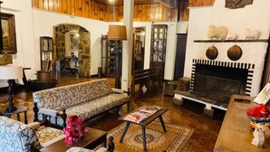 A cozy living room with a patterned sofa, a coffee table, and a fireplace. - Hotel Terrazza (Campos do Jordão)