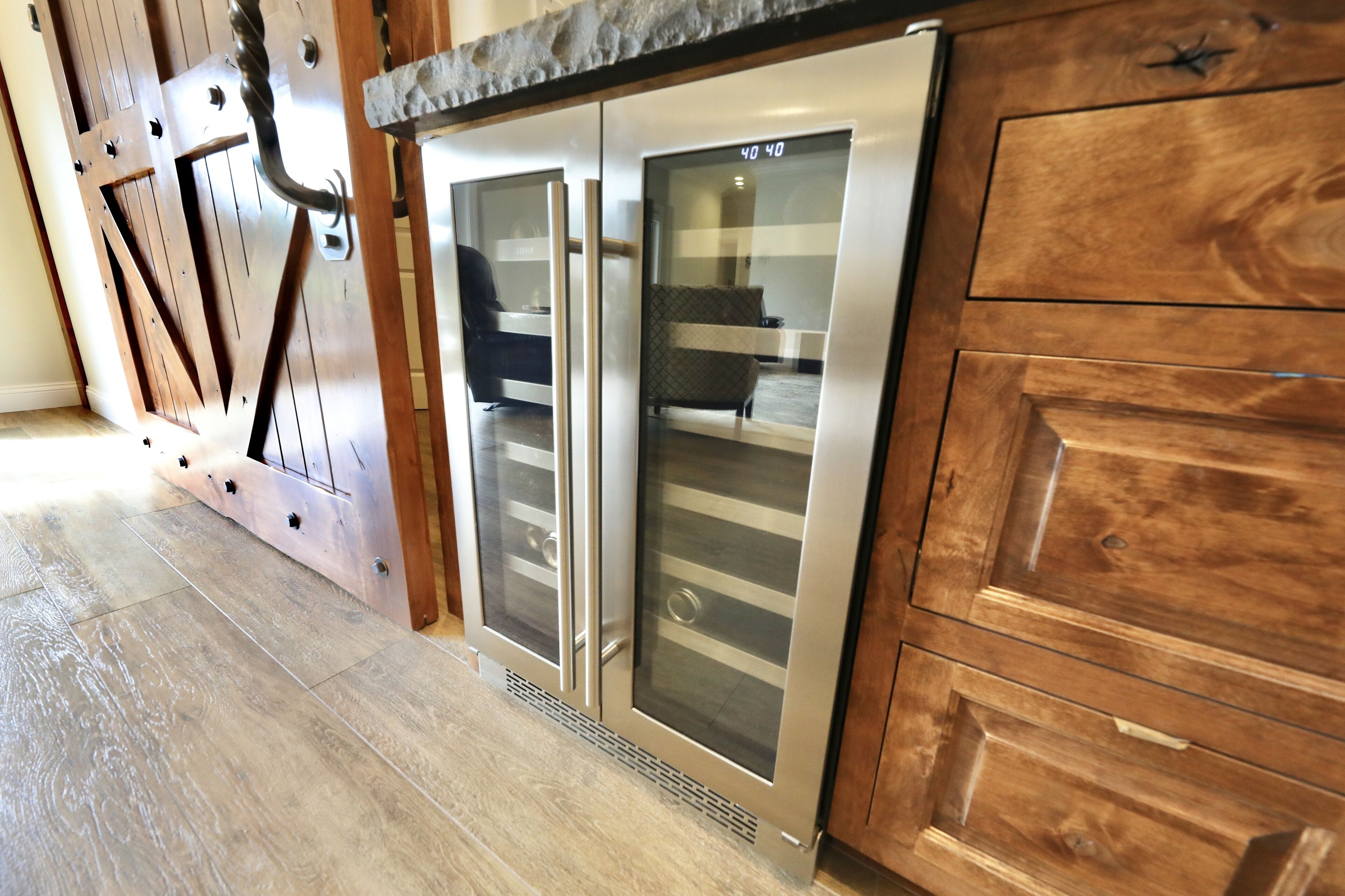 Eine moderne Küche mit Holzausstattung und Edelstahlgeräten, darunter ein Kühlschrank und ein Backofen.