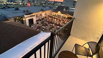 Una terraza en la azotea con mobiliario exterior, vistas panorámicas de la ciudad y cielo despejado.