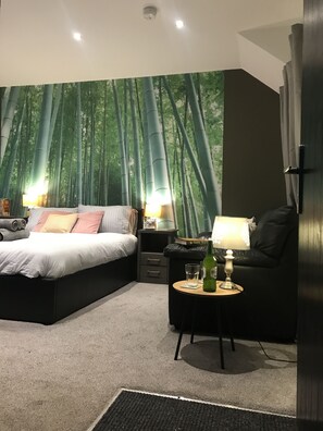 A bedroom with a bed, bedside tables, a lamp, and a bookshelf. - Contemporary 1 bed Studio for Comfy Stay in Wigan (Wigan)