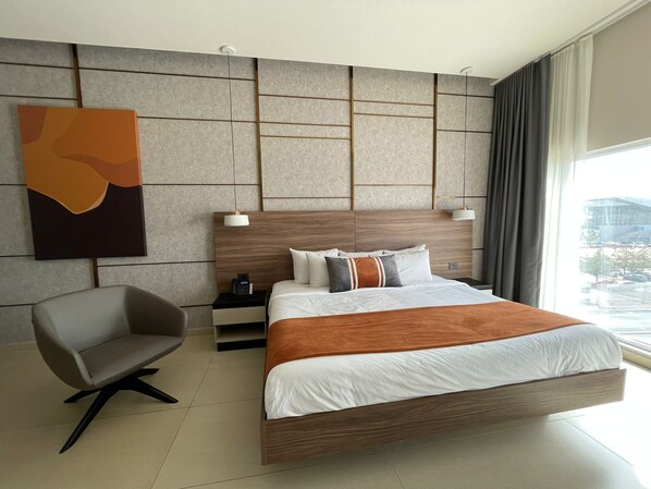 Una habitación de hotel moderna con una cama grande, un escritorio y una silla.