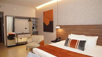 Une chambre d’hôtel avec un lit, une chaise, un bureau, une armoire et un tableau au mur.