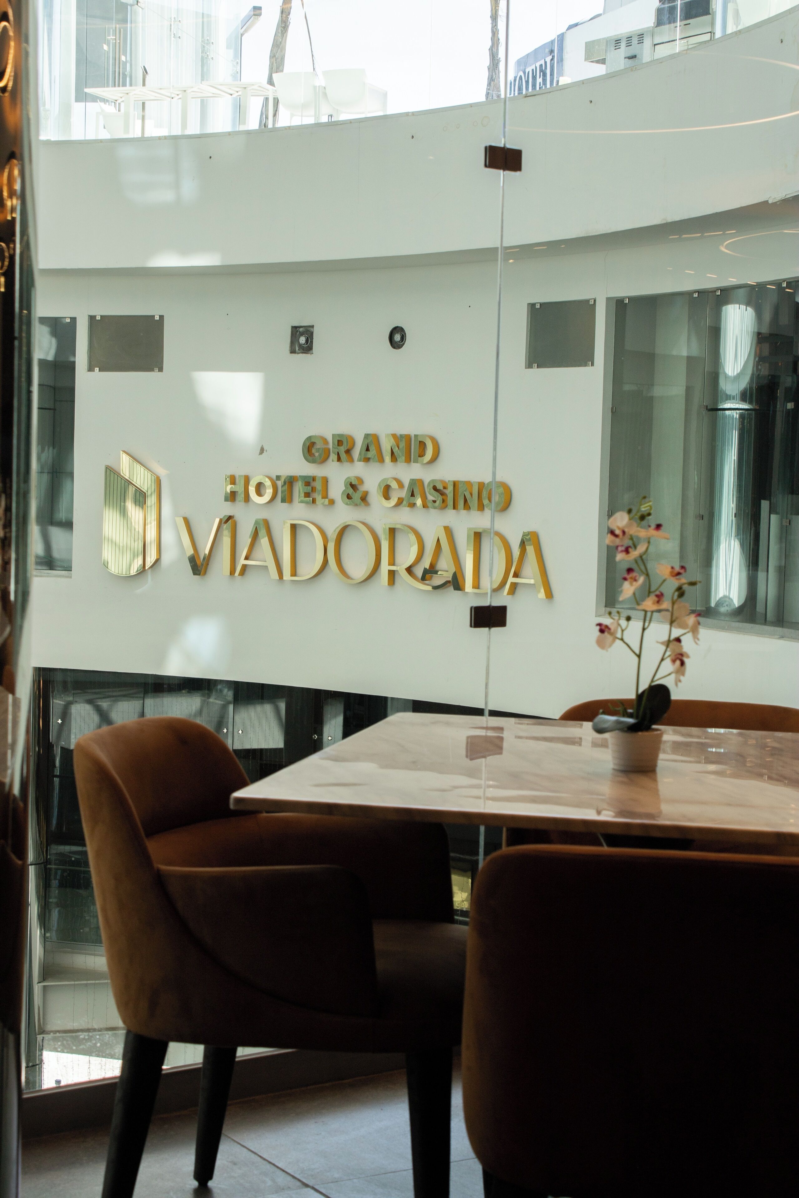 A modern interior with a sign for 'Grand Hotel & Casino Vidorada'.