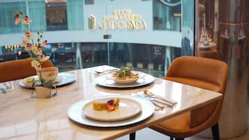 Una mesa de comedor con platos, cubiertos y una decoración floral en un hotel.