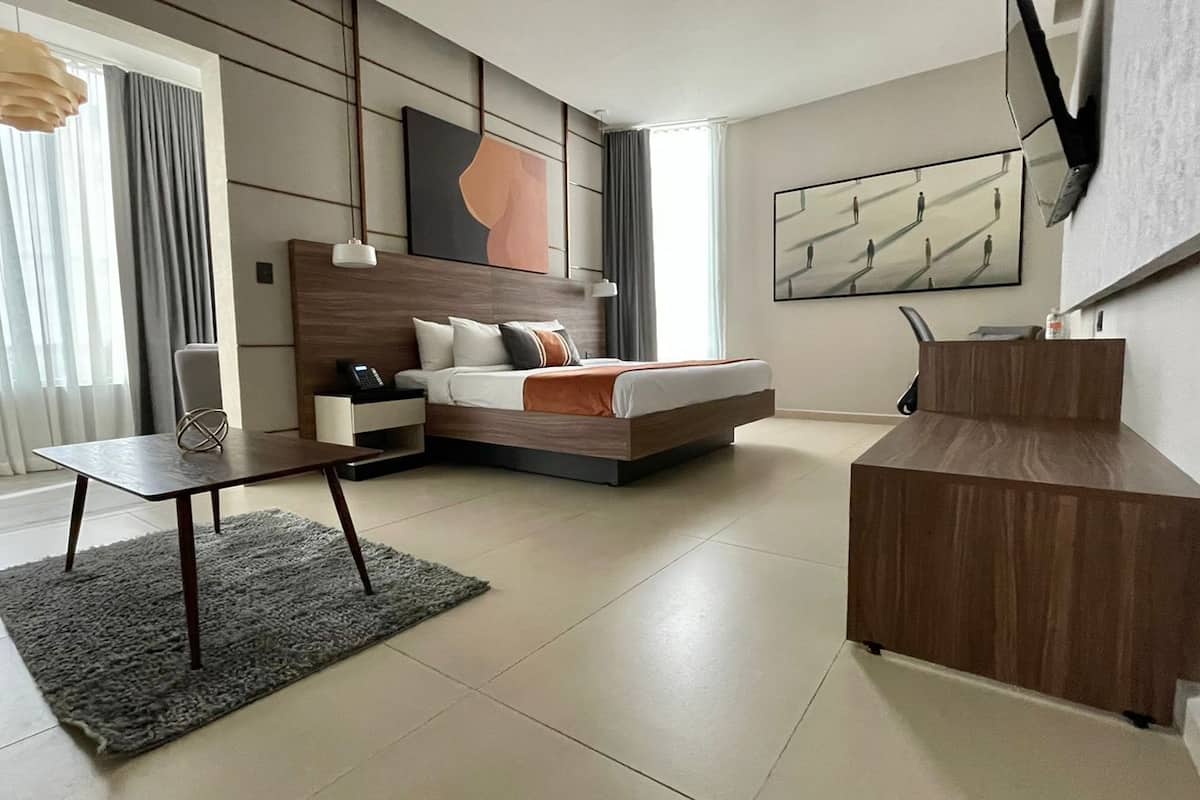 Un dormitorio moderno con cama, mesita de noche y escritorio con silla.