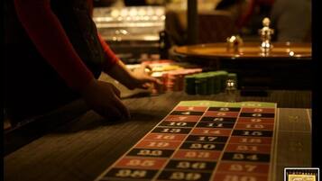 Une roulette avec des cases numérotées et une main qui place des jetons sur le tapis.