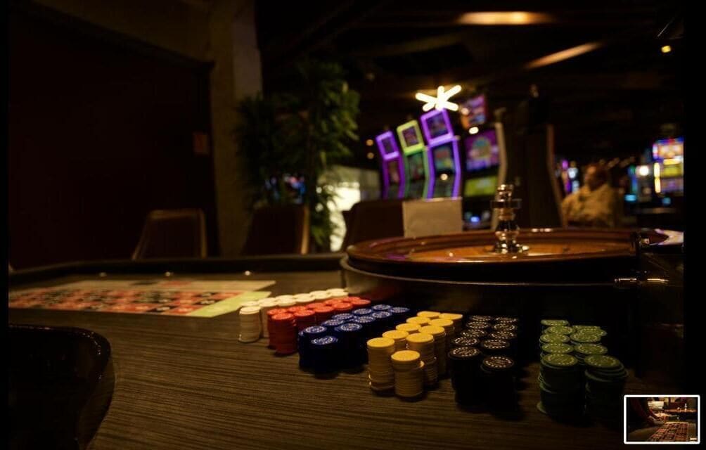 Una mesa de casino con fichas de póker y una ruleta.