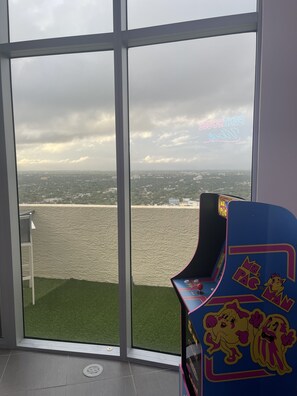 Enjoy a view of the water and city from the large window, with a colorful arcade machine and comfortable space to unwind.