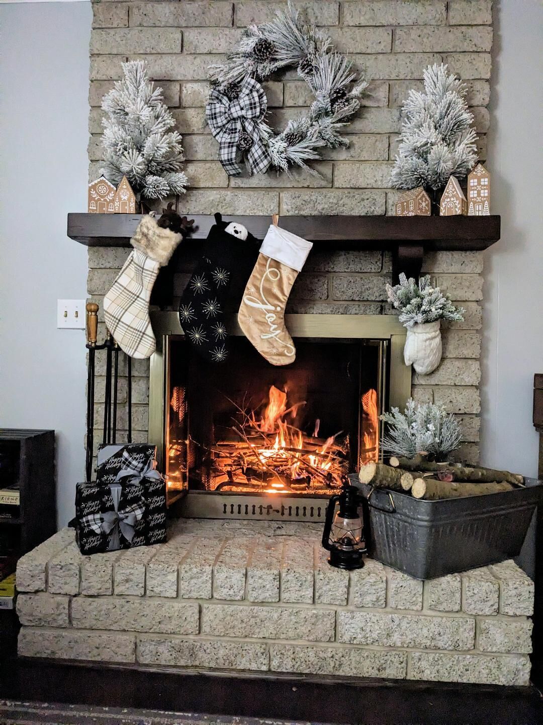A fireplace with stockings hanging, a brick wall, and a wreath above.