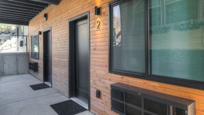 Un edificio moderno con paneles de madera, puertas numeradas y ventanas amplias.