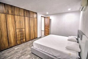 Une chambre à coucher avec un lit, une armoire en bois et une porte.