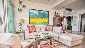 Un salón amplio con un sofá grande, una mesa de centro y un cuadro en la pared.