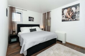 Une chambre à coucher avec un lit, une table de chevet, un radiateur et un tableau au mur.